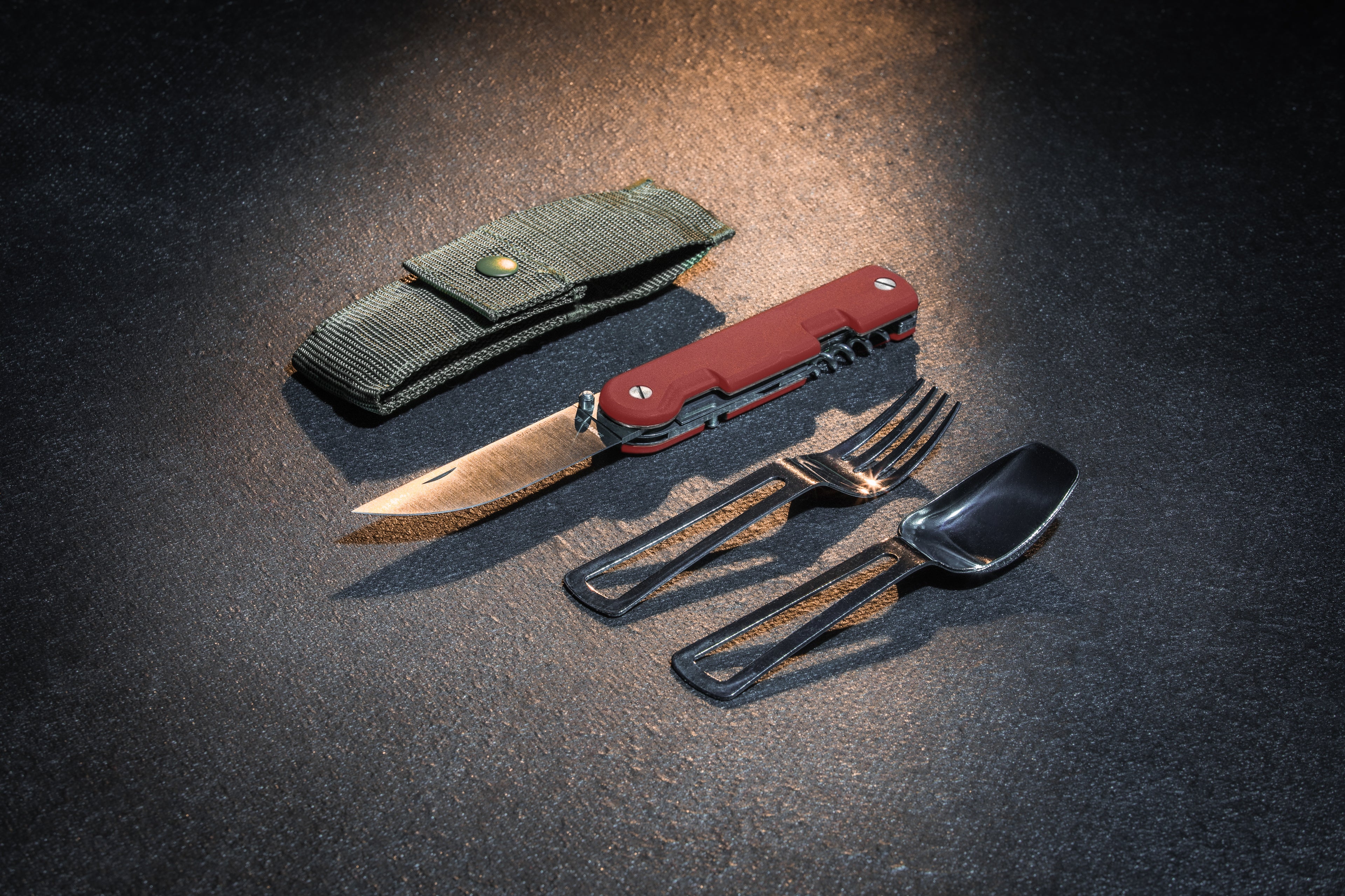 Couteau baroudeur rouge ouvert avec ses couverts son étui textile sur fond noir